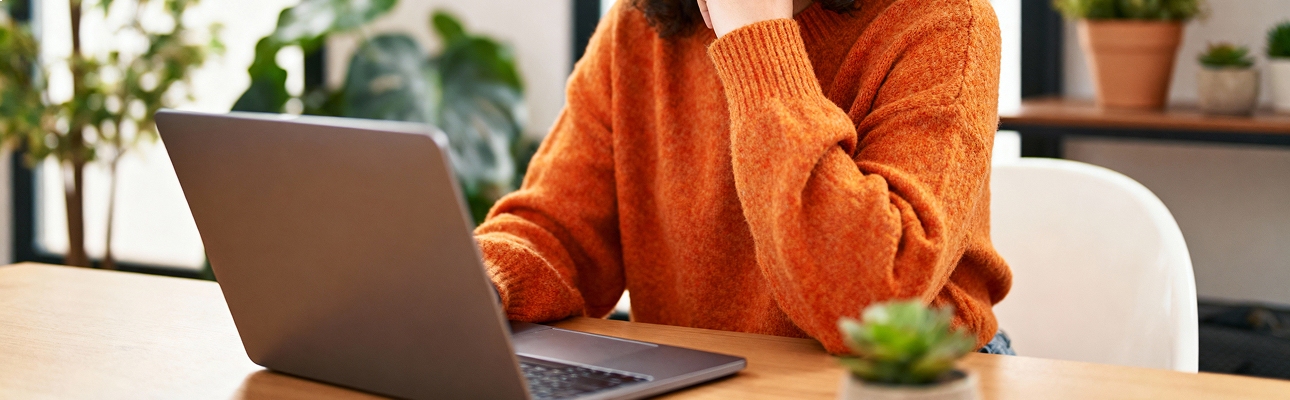 Personne travaillant sur un ordinateur portable dans un bureau lumineux, bannière contact
