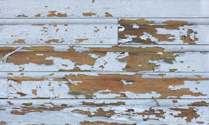 Bardage en bois avec peinture bleue écaillée, illustrant le diagnostic plomb